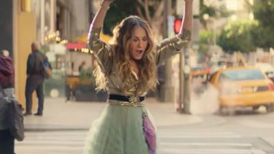 WATCH: Carrie Bradshaw Is Back & She’s Still Getting Splashed By Buses, FFS