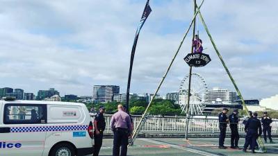 QLD Climate Activist Arrested After Dangling Self From Tripod, Blocking Traffic