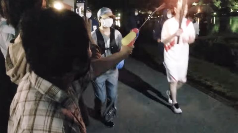 A Japanese Woman Armed With A Super Soaker Tried To Extinguish The Olympic Torch In Protest