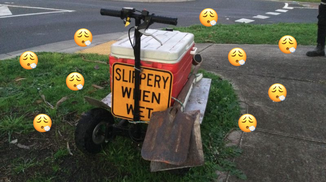 A photo of a red Esky on a scooter with a 'Slippery when wet' warning sign on it and face exhaling emojis scattered over it