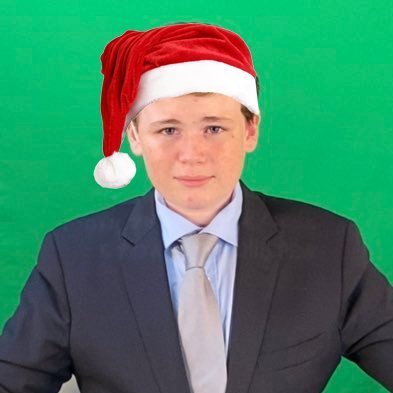 14-year-old journalist Leonardo Puglisi wearing a santa hat and suit in front of a green screen