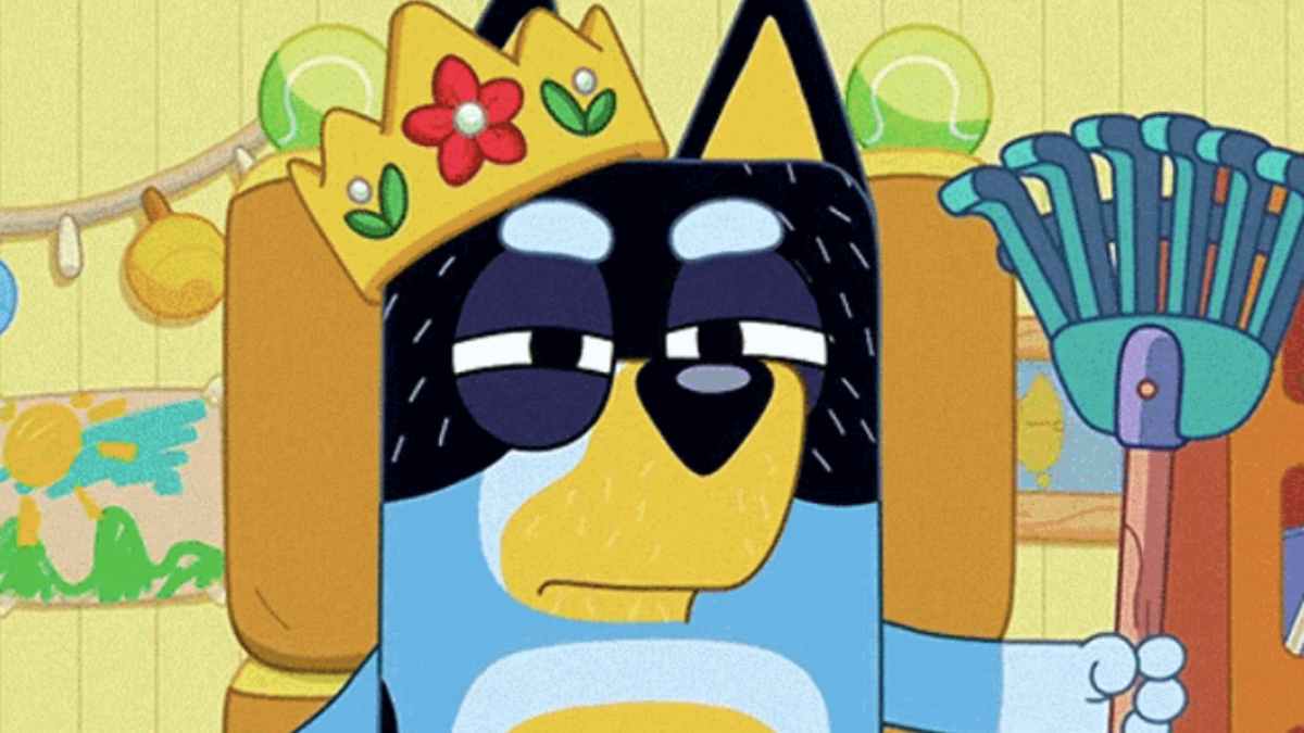 Bandit in Bluey wearing a crown and holding a garden rake, looking vengeful