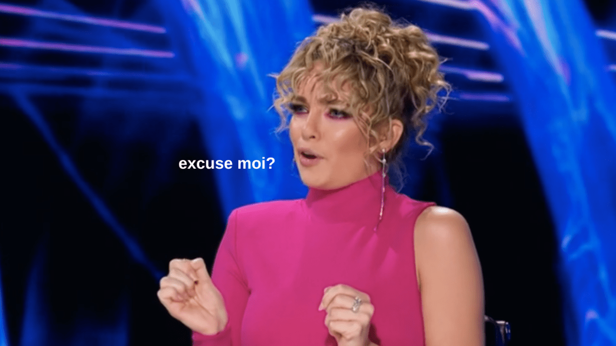 Abbie Chatfield wearing a pink dress while appearing as a judge on The Masked Singer, with text that reads "excuse moi?"