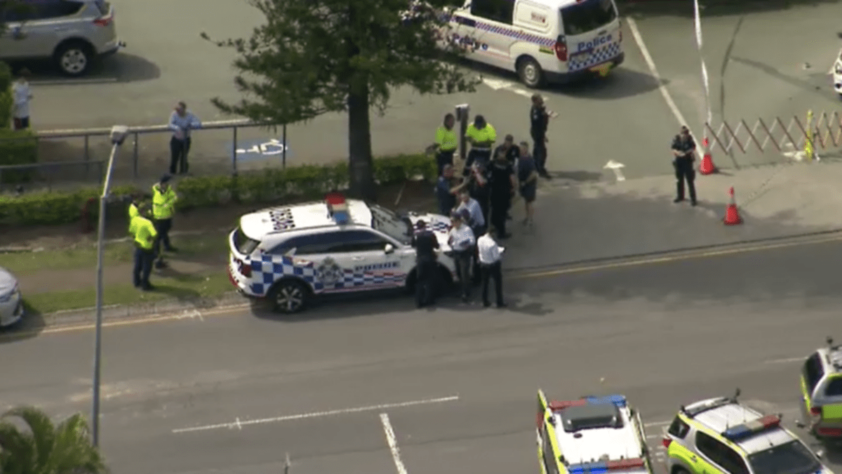 Queensland Police car parked on road and emergency services gathered around following a stabbing in south-east Brisbane