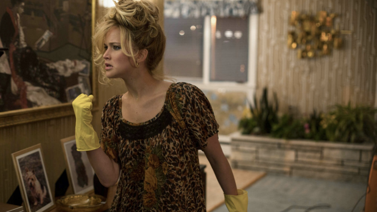 Jennifer Lawrence in American Hustle wearing a short-sleeved leopard print dress and yellow cleaning gloves
