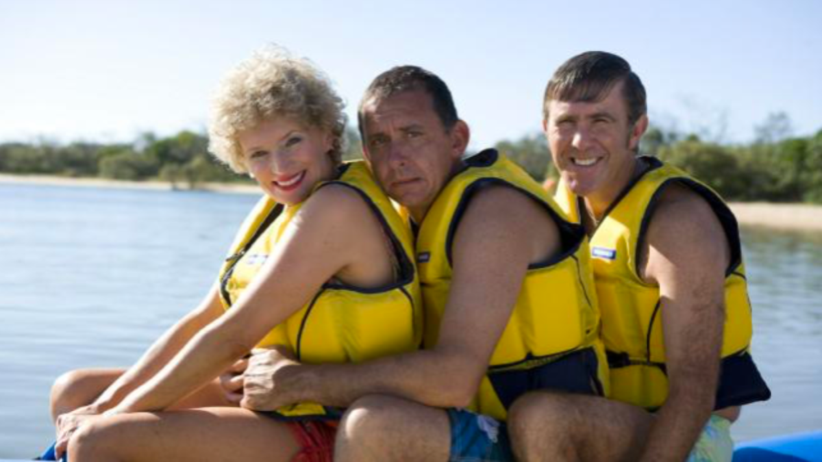 Kath Day-Knight, Brett Craig and Kel Knight wearing yellow life jackets on a jet ski in Kath & Kim