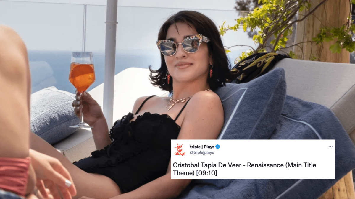 Lucia in The White Lotus, played by Simona Tabasco, relaxing on a beach chair drinking an Aperol spritz wearing a black swimsuit with a Tweet overlaid which reads: Cristobal Tapia De Veer - Renaissance (Main Title Theme) [09:10]