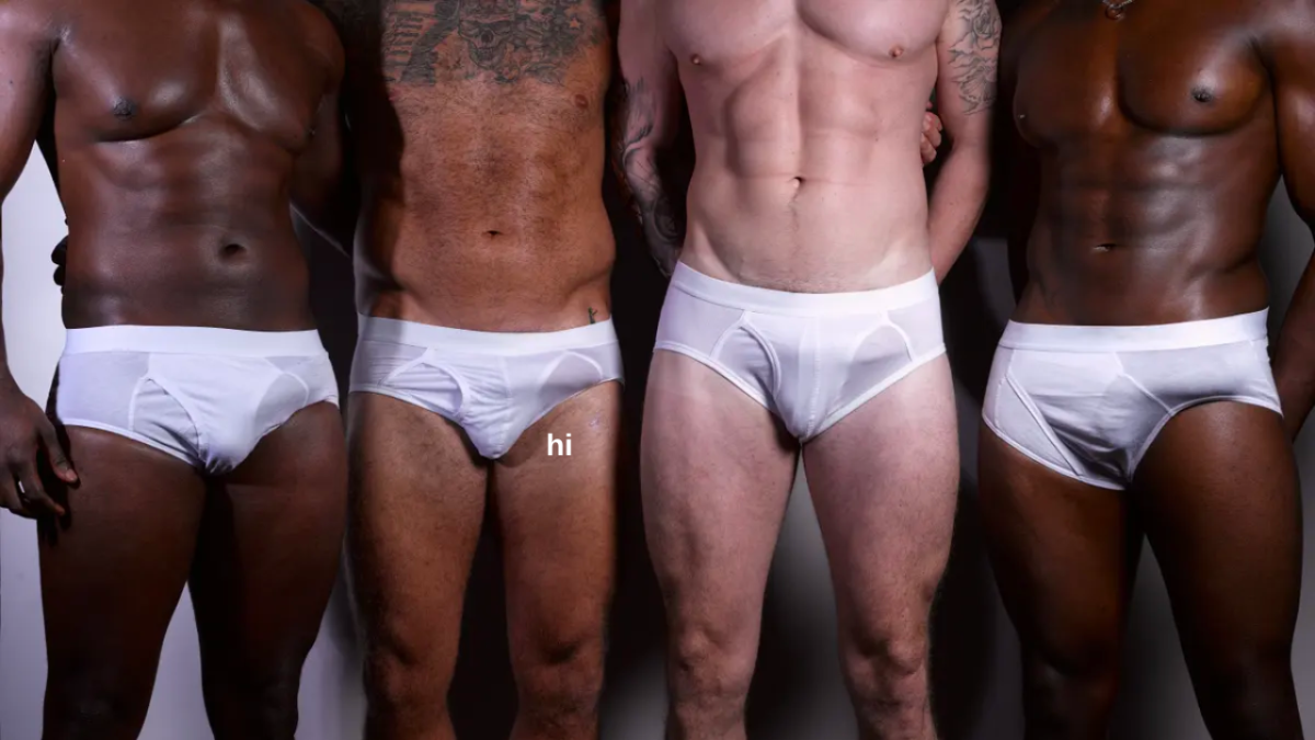 four men standing in white undies shirtless with small text which reads "hi" in white leters