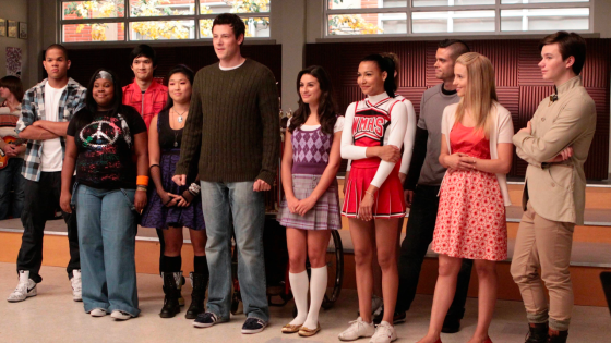 Glee cast standing in music room