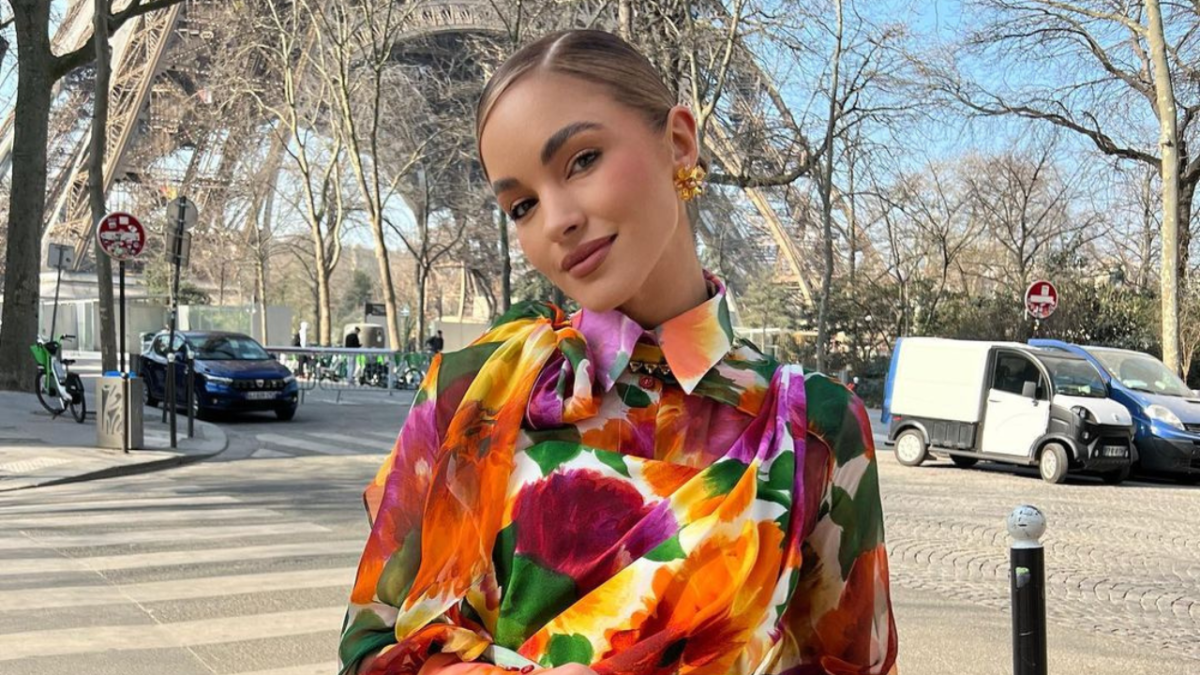 Australian influencer Olivia Molly Rogers posing in a floral dress in front of the Eiffel Tower in Paris