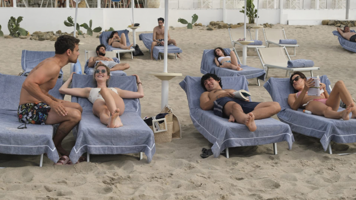 Cameron, Daphne, Will and Harper in The White Lotus lounging on chairs on the beach