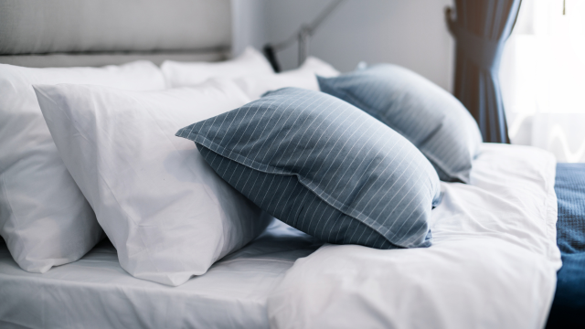 Photo of grey and white pillows on a hotel bed