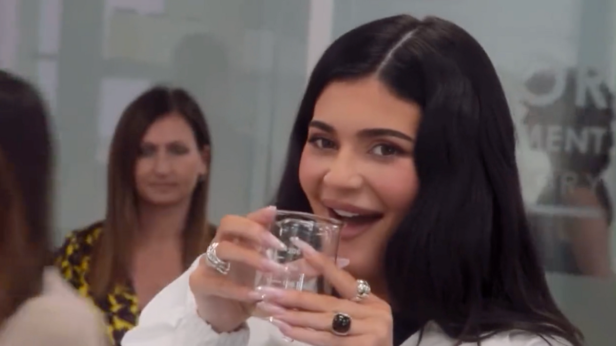 Kylie Jenner holding beaker to her mouth while visiting Kylie Cosmetics factory in Milan