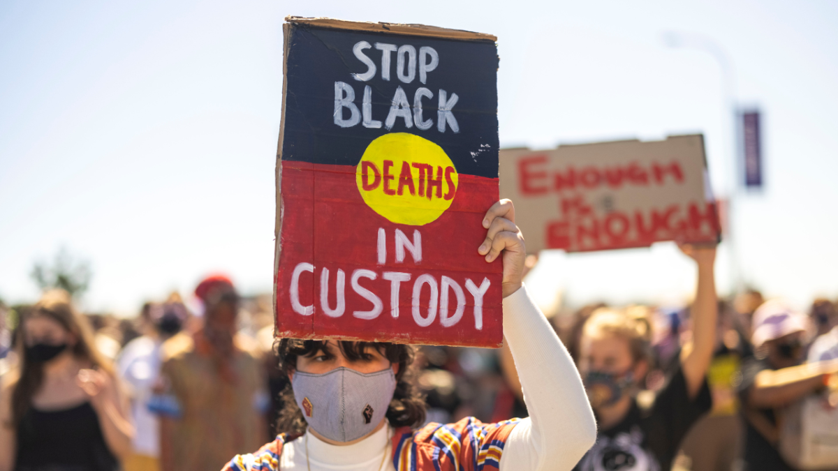 a stop black deaths in custody sign. an aboriginal man has died in custody in WA and is the 80th australian to die in custody this year.