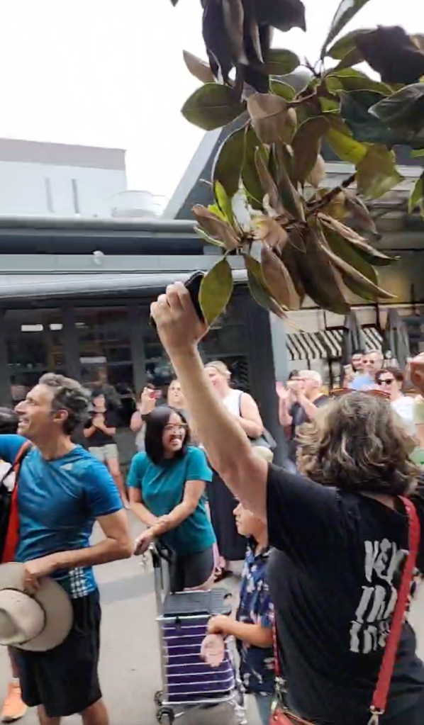 Locals celebrating the opening of the notorious Ashfield Mall escalator. Image: Facebook / Jack Wimborne