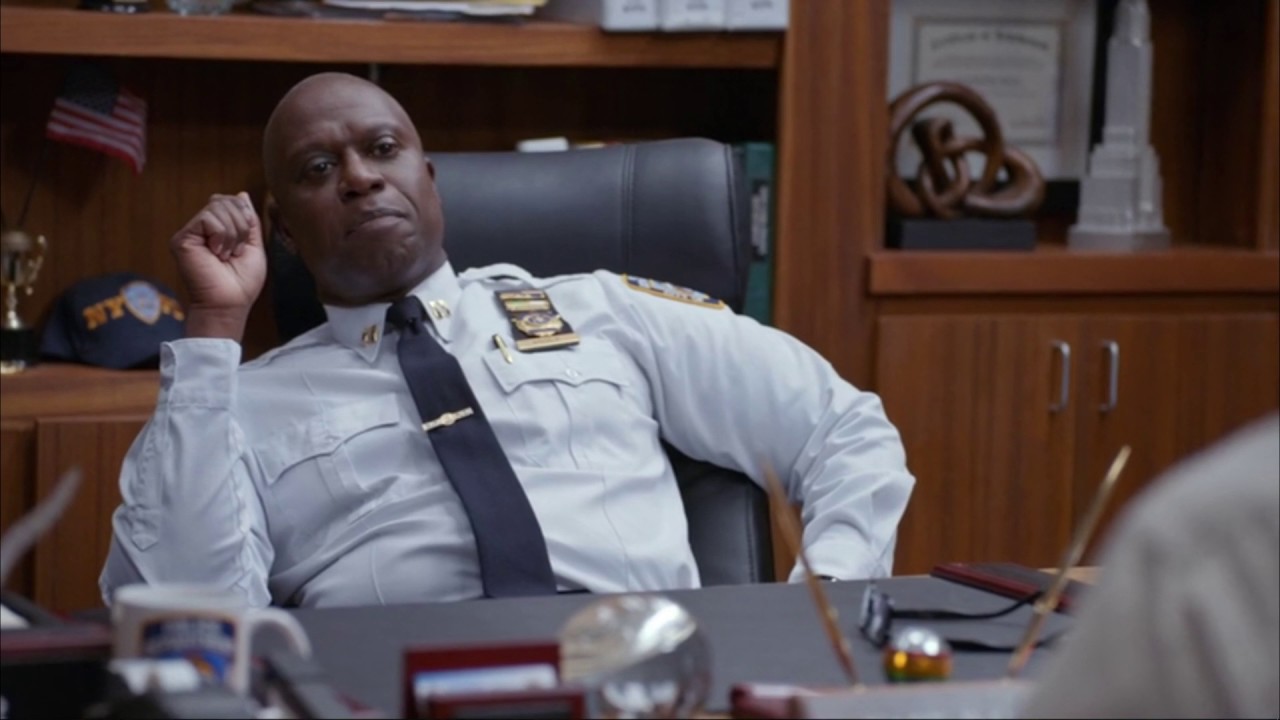 Andre Braugher as Captain Raymond Holt in Brooklyn Nine-Nine, leaning back in an office chair.